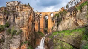 Foto panorámica de la ciudad de Ronda, se ve un precipicio partido en dos y unido por un puente de piedra precoiso de estilo medieval